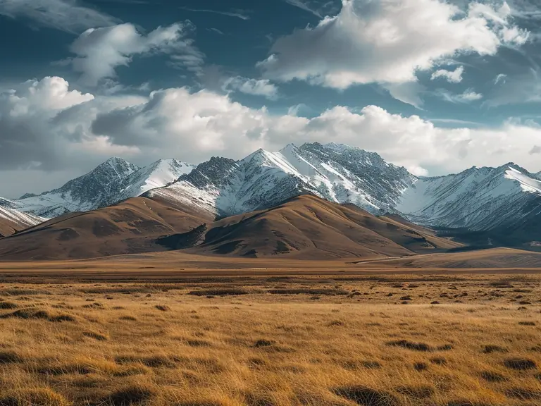 Wide steppes and snow-capped peaks of Kazakhstan under a partly cloudy sky