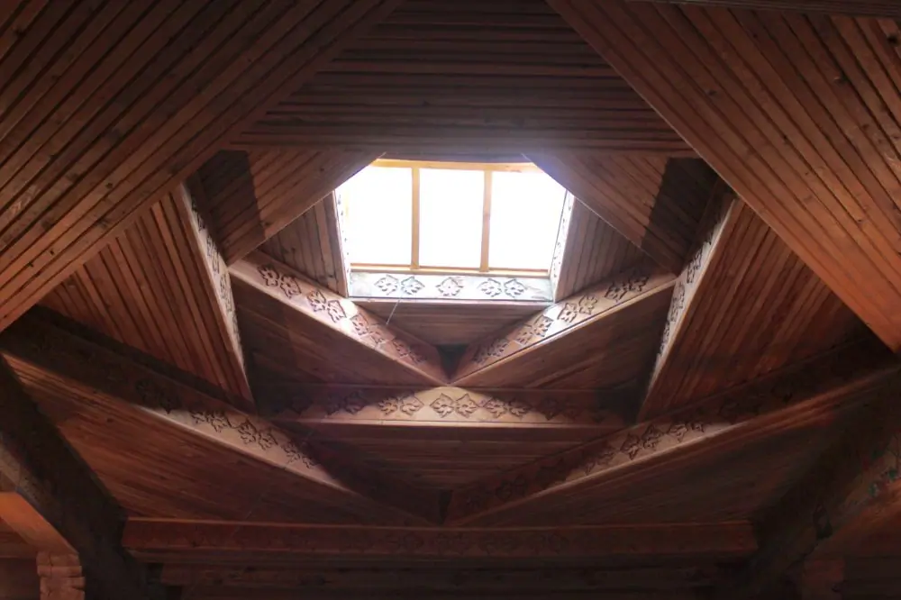 Interior of a traditional pamiri house with the wooden roof and carpet on the floor and on the wall