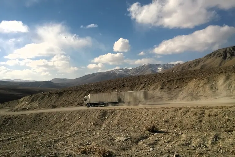 A chinese truck is driving down the Koj Tezek pass into the Gunt valley, on the way to Khorog, road M41