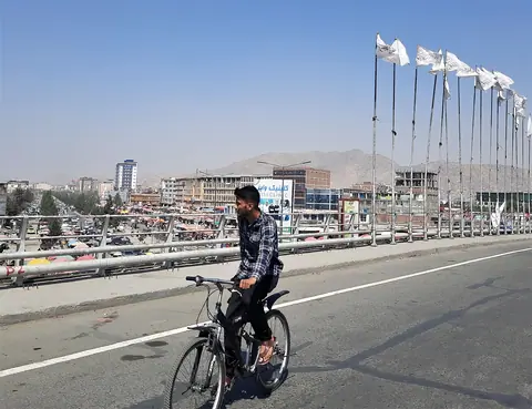A biker on the bridge in the city center of Kabul