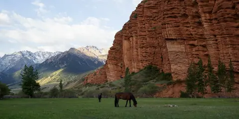 Horses grazing, red rocks in Jeti Oguz, Kyrgyzstan