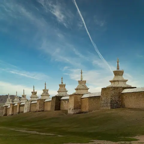 a group of stupas sitting on top of a lush green field