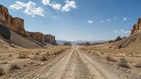 Driving through Turkmenistan's landscapes, wide-angle shot of Karakum Desert with golden sands and open road