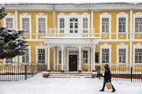 Karakol's historic pedagogical school building covered in snow in winter