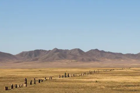 stone poles are standing in the middle of the steppes