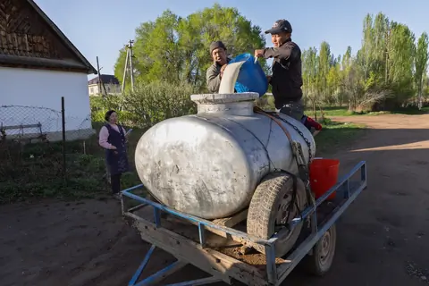 Two men collecting milk in the village of Svetlana Polyana