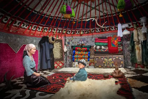 Nurai and her son sitting in the exibition yurt of Orgochor - Svetlana Polyana museum