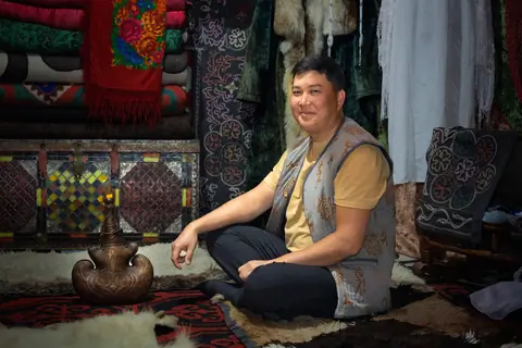 Tilekmat sitting under the yurt of Orgochor - Svetlana Polyana museum 