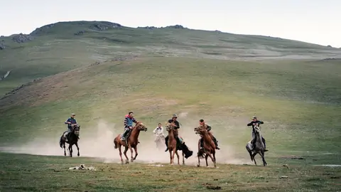young riders racing on horseback in Son Kul