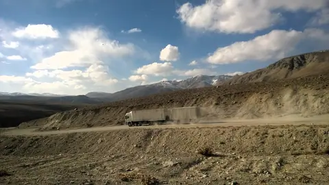 A chinese truck is driving down the Koj Tezek pass into the Gunt valley, on the way to Khorog, road M41
