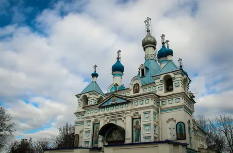 View of the main bell tower, painted in light blue and white, with a gilded onion dome at the top of the Cathedral of the Assumption of the Virgin in Tashkent