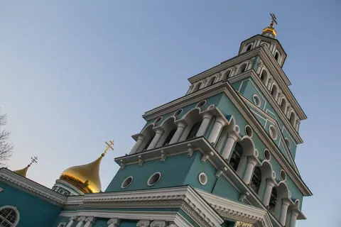 View of the main bell tower, painted in light blue and white, with a gilded onion dome at the top of the Cathedral of the Assumption of the Virgin in Tashkent