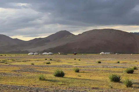 Sunset on yurt camps surrounding the village of Sagsay in the Bayan Ulgii region of Mongolia, cloudy sky, sunny on pasture and yurts