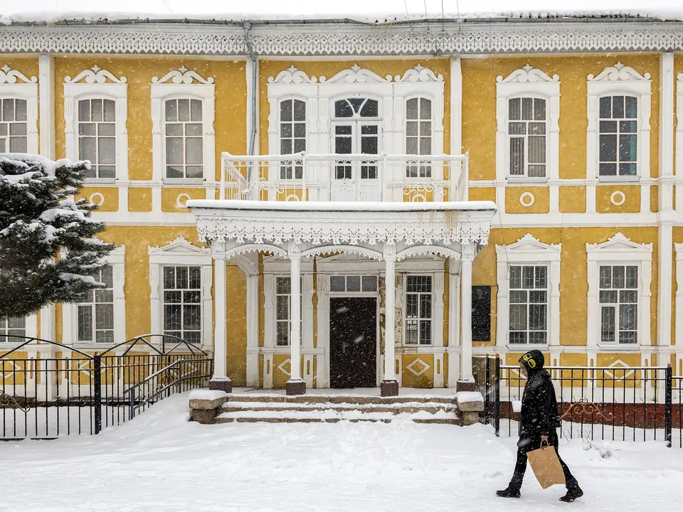 Karakol's historic pedagogical school building covered in snow in winter