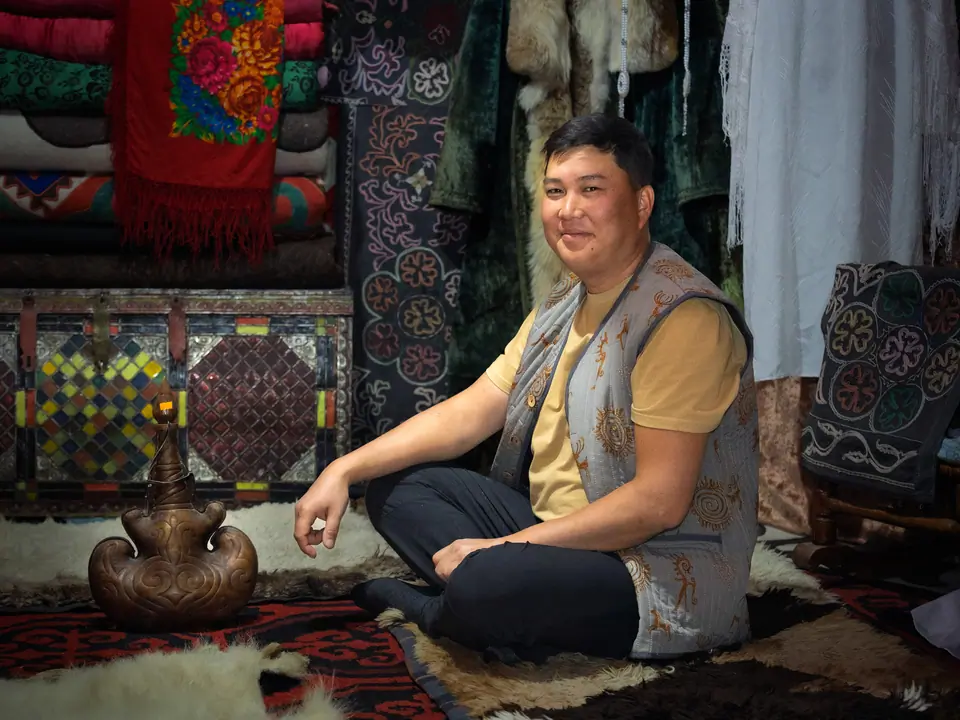 Tilekmat sitting under the yurt of Orgochor - Svetlana Polyana museum 
