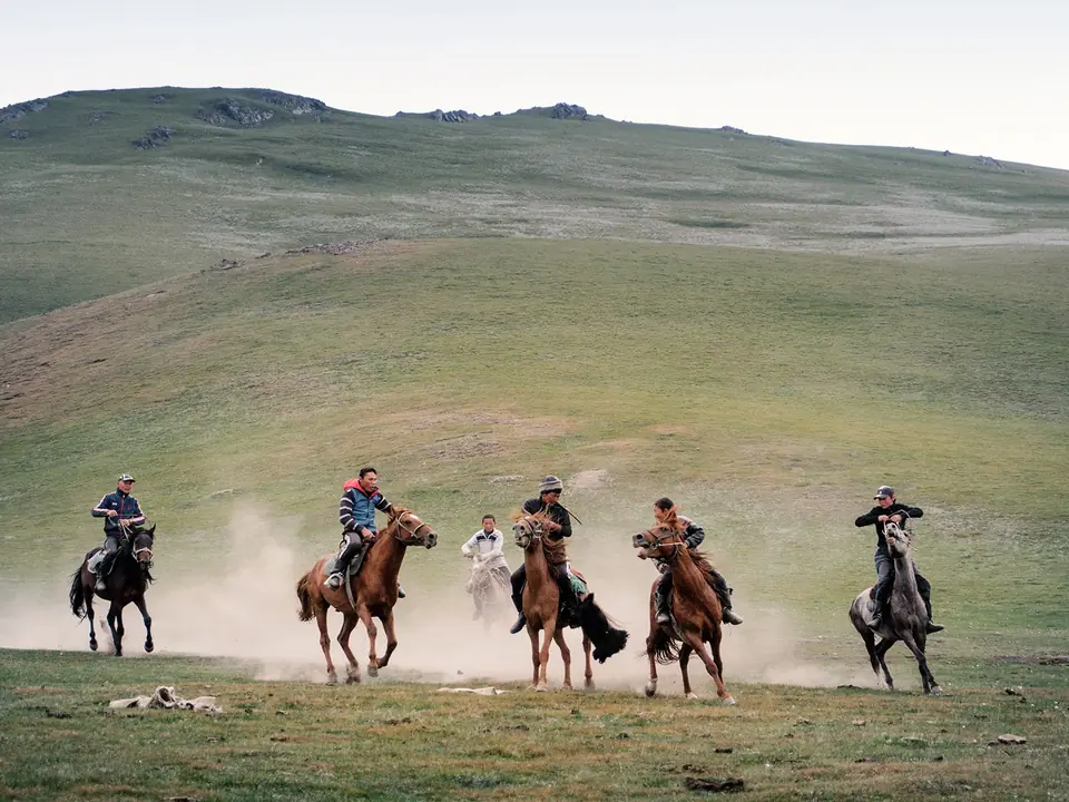 young riders racing on horseback in Son Kul