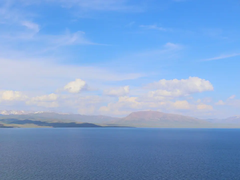 View from the West shore of the Song Kul lake, here the White stone mount seems red backside of the blue of the lake
