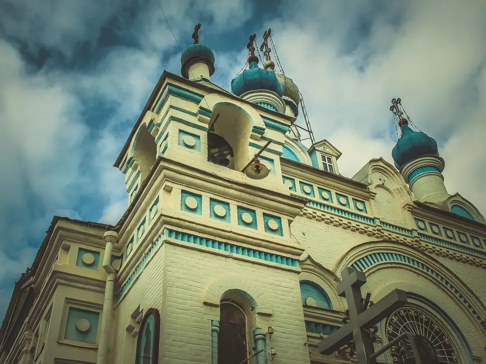 View of the main bell tower, painted in light blue and white, with a gilded onion dome at the top of the Cathedral of the Assumption of the Virgin in Tashkent