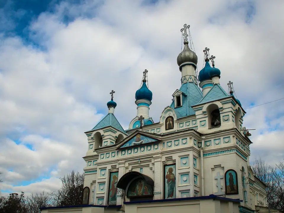 View of the main bell tower, painted in light blue and white, with a gilded onion dome at the top of the Cathedral of the Assumption of the Virgin in Tashkent