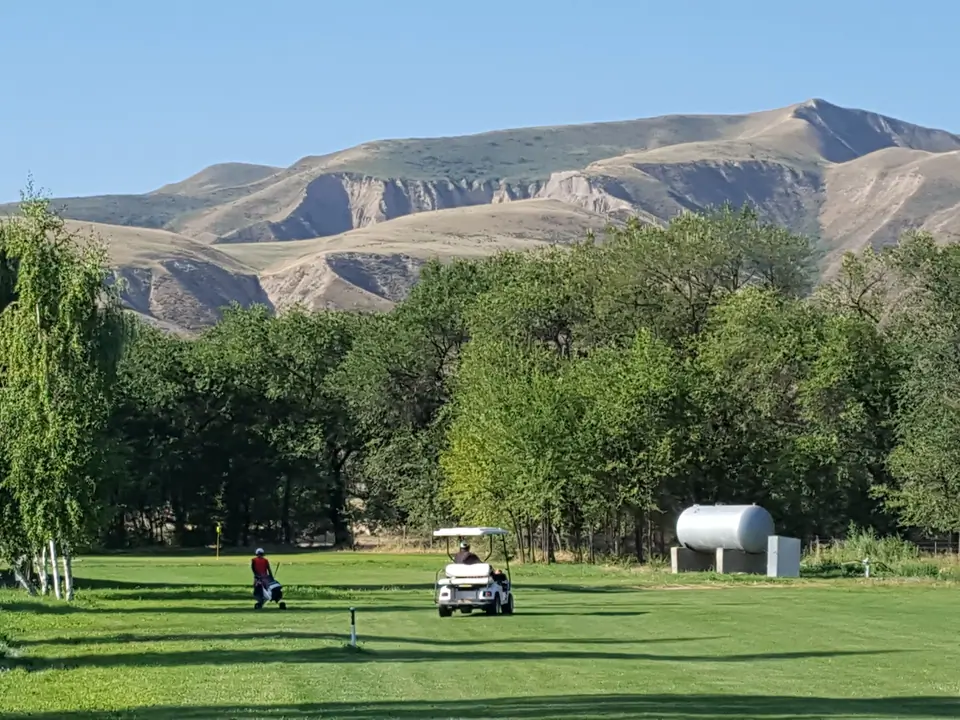 Golf course with golfer on the green of the Maple Golf club of Bishkek