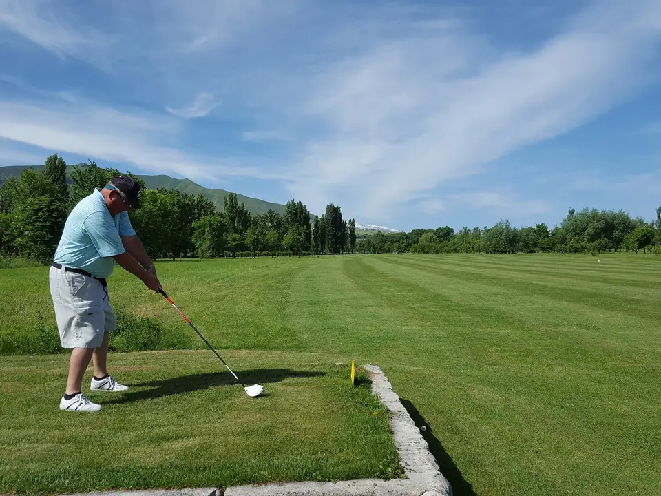 Golf course with golfer on the green of the Maple Golf club of Bishkek