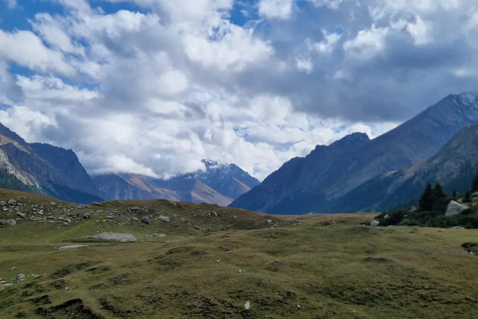 The valley of Turgen Ak-Suu in autumn, surrounding by high peaks, green pastures for nomads