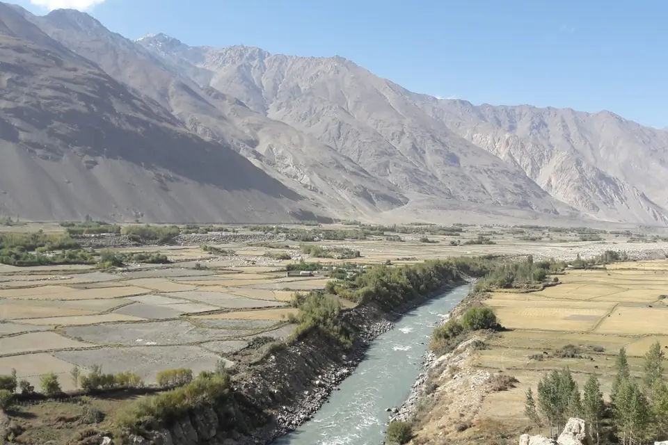 panoramic views unfold across the fertile floodplains below—patchworks of golden fields, poplar groves, and grazing livestock on both the Tajik and Afghan sides, from the Khakhka fortress