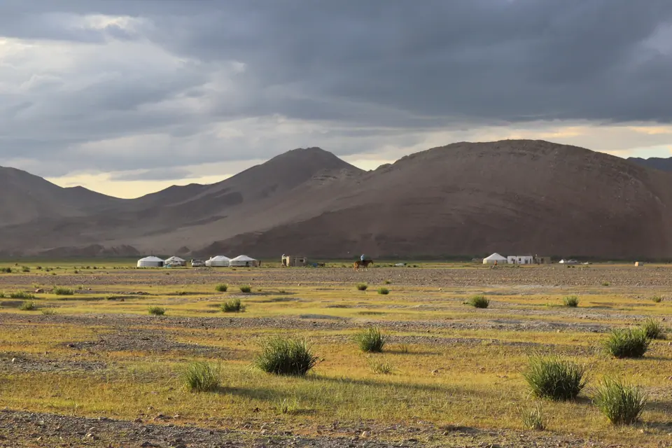 Sunset on yurt camps surrounding the village of Sagsay in the Bayan Ulgii region of Mongolia, cloudy sky, sunny on pasture and yurts