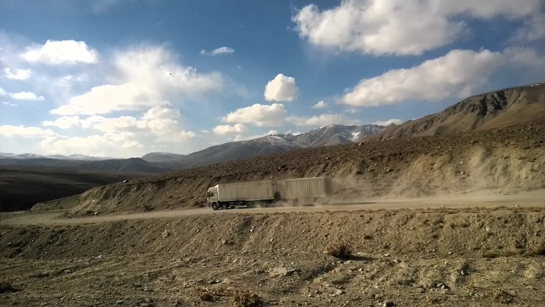A chinese truck is driving down the Koj Tezek pass into the Gunt valley, on the way to Khorog, road M41